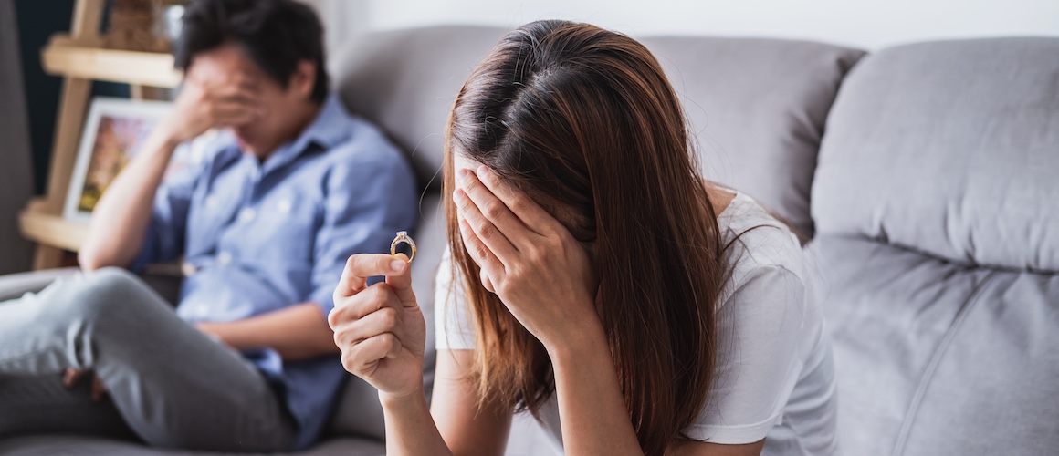 Frustrated sad wife taking off the wedding ring, Young couple breaking up