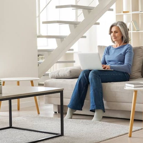 A senior couple relaxing on couches in a living room, indicating a comfortable and relaxed retirement setting.