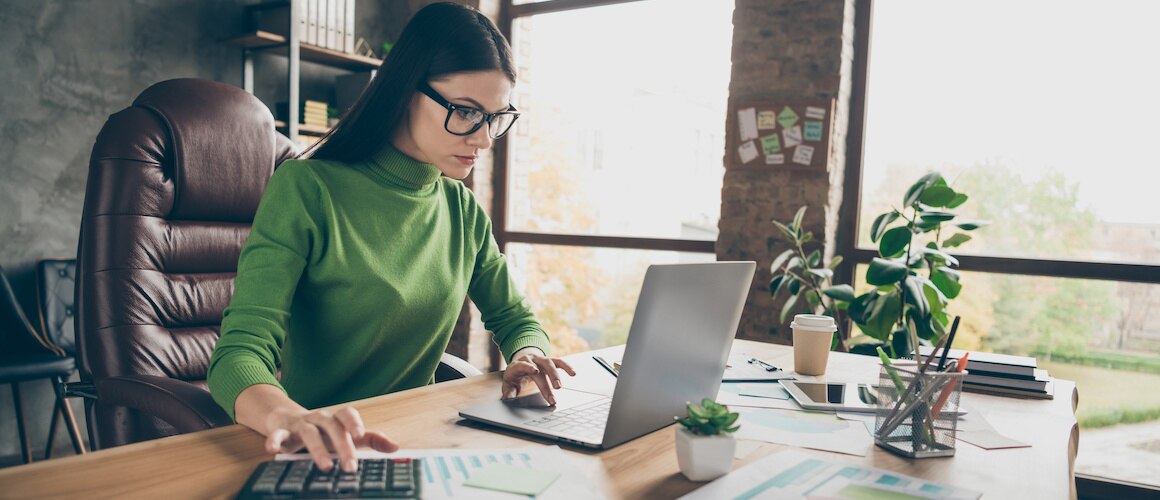 RHB Assets From IGX: Woman sitting at a table, calculating home value with documents and a calculator.