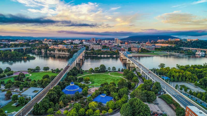 RHB Assets From IGX: Scenic aerial view of Chattanooga, Tennessee, with a river and surrounding mountains.