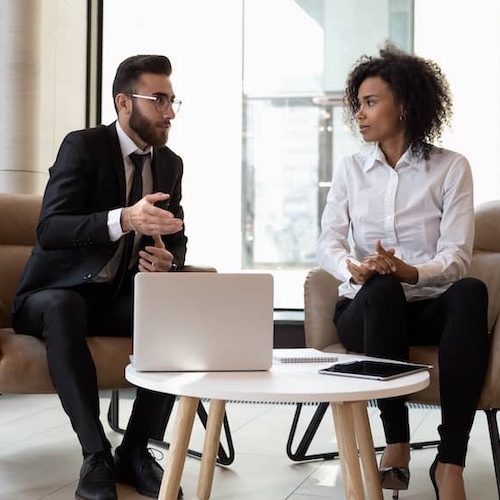 Two business people in a meeting together while having a discussion.