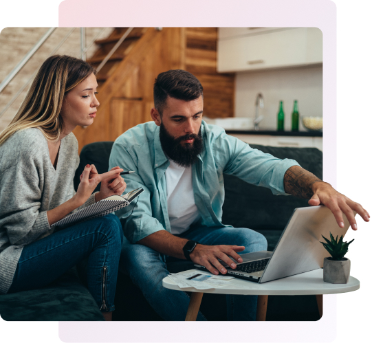 A couple in their 30s look at a laptop and discuss their options for home financing. 