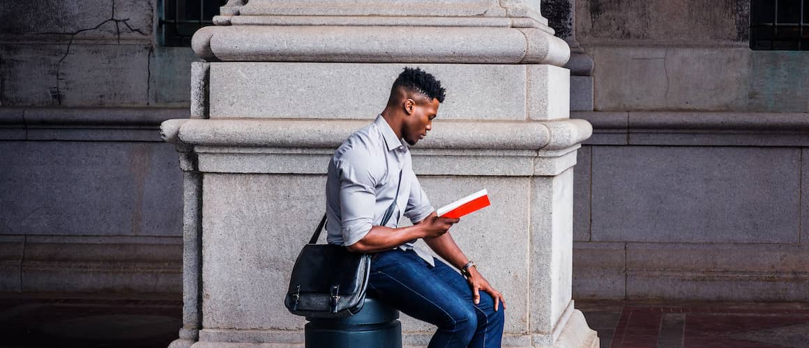 A man engrossed in reading, possibly studying or enjoying a book.