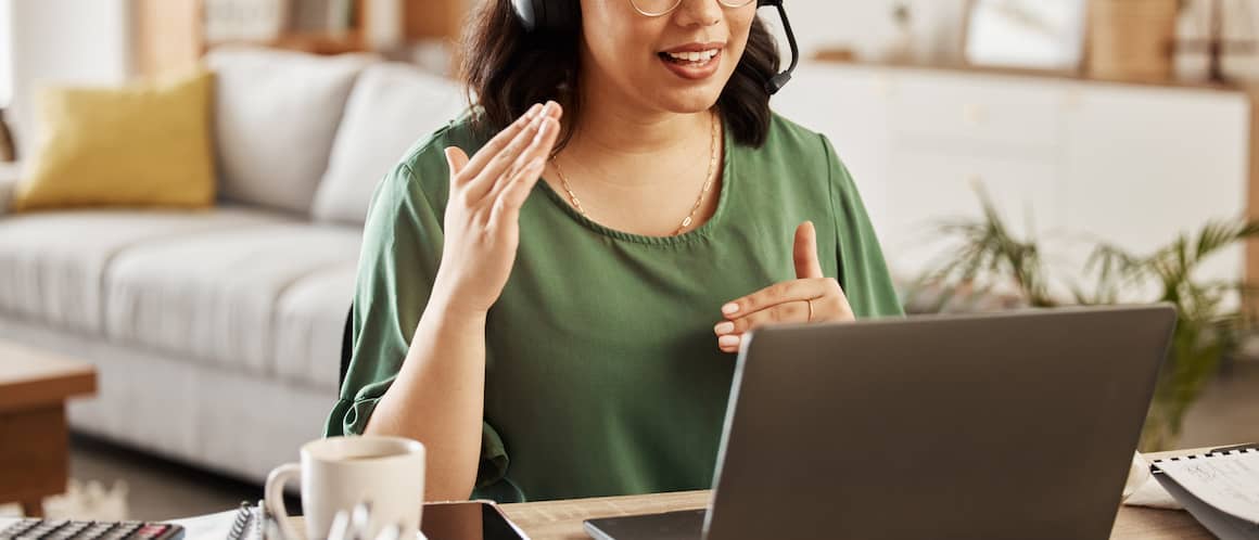 A woman in middle of call or meeting talking with either colleague or customer.