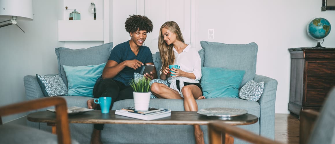 Two people sitting on a couch in a cozy living room, engaged in conversation and enjoying each other's company.