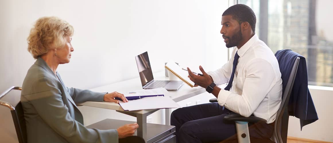 Senior Woman Meeting With Male Financial Advisor In Office