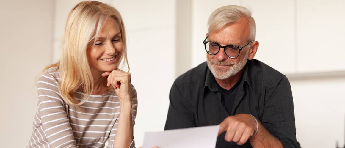 Middle-aged couple looking at paperwork together.