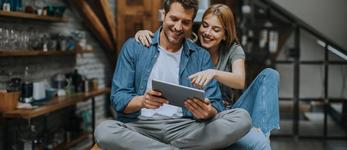 RHB Assets From IGX: Couple looking at a tablet in a kitchen