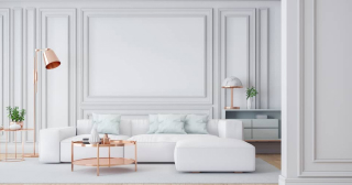 A modern all-white living room with a large sectional couch and copper accent pieces.