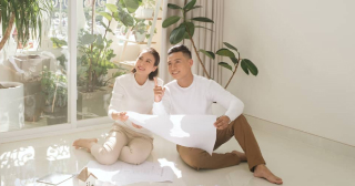 This young Asian couple looking at remodeling plans took out a second mortgage to fund the improvements.