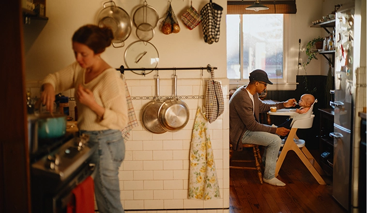 A young white woman hugs her partner while holding the keys to their new home.