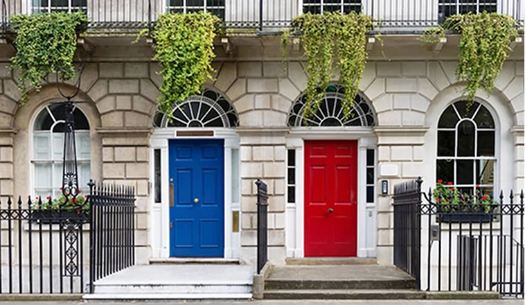 Front view of similar brick houses with red and blue door.