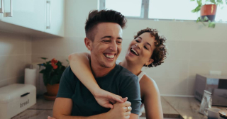 Thinking about remodeling their kitchen with a Home Equity Loan, a young couple enjoy a happy and playful moment.