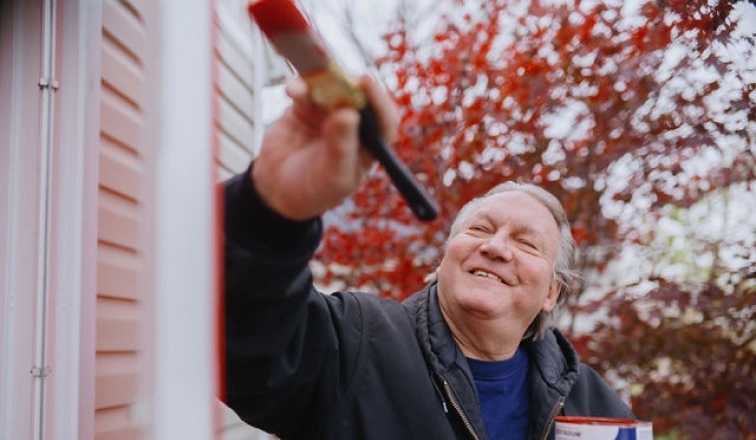 A home equity loan from Rocket Mortgage can help fund home improvements, like the painting project this mature man with silver hair.