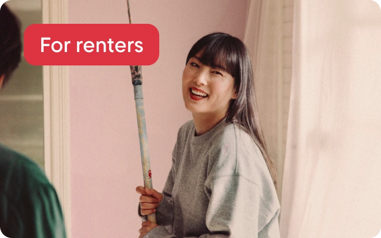 A woman with dark hair laughing while painting a bedroom. A graphic tag says "For renters". 