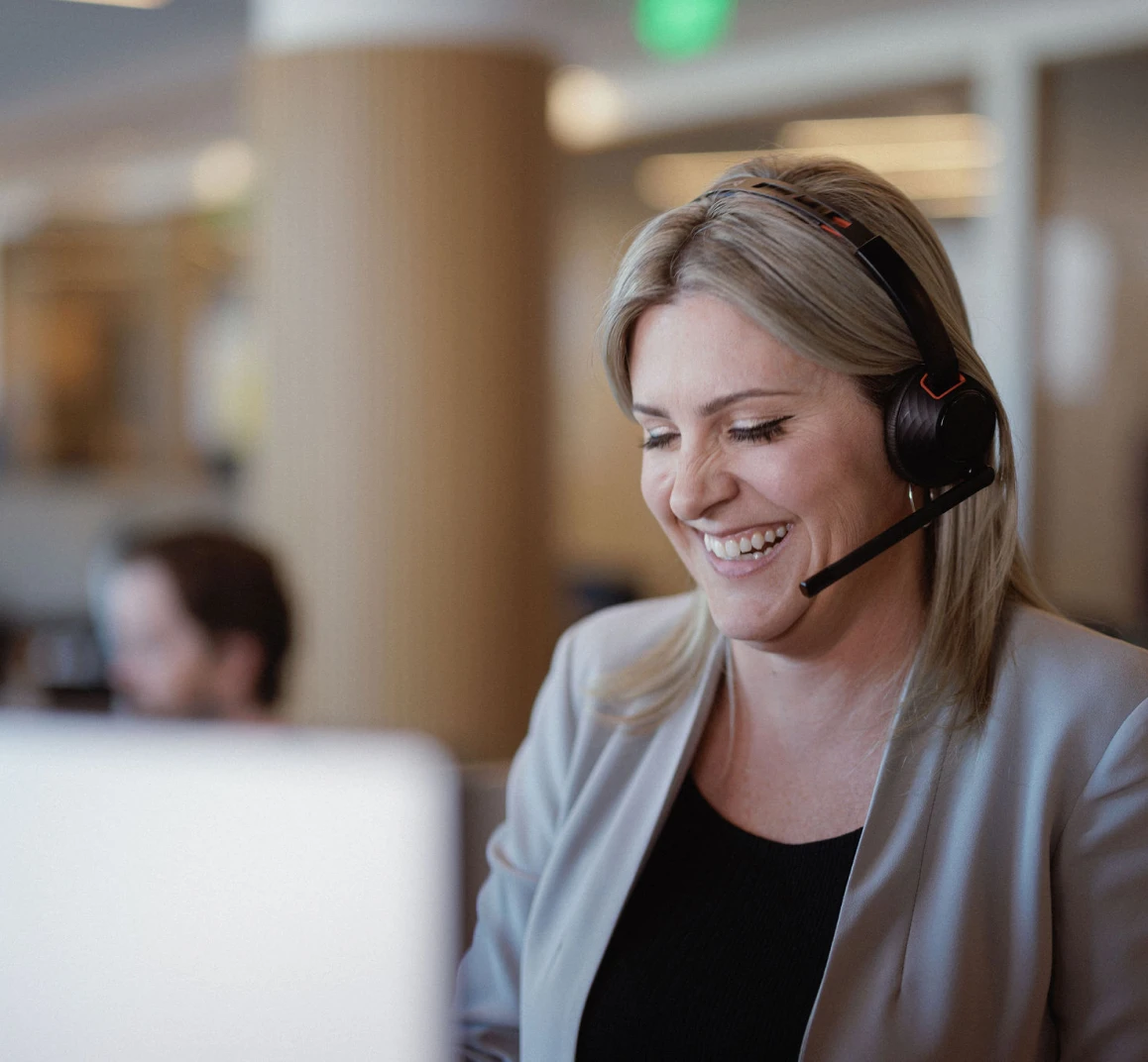 The loan officers at Rocket Mortgage, like this woman with blonde hair wearing a headset and a beige blazer, are here to help real estate agents help their clients.