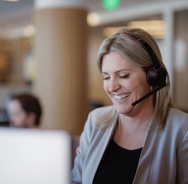 The loan officers at Rocket Mortgage, like this woman with blonde hair wearing a headset and a beige blazer, are here to help real estate agents help their clients.