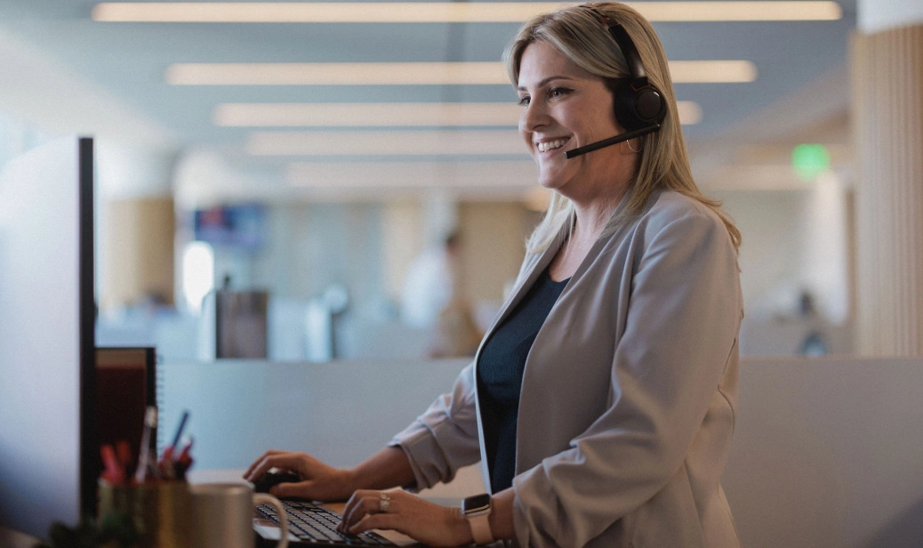 Loan officers at Rocket Mortgage  like this woman wearing a beige blazer and a headset at computer keyboard are focused on the success of our real estate agent partners.