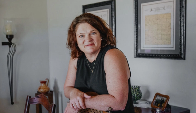 Rocket Mortgage helps people like this white woman with auburn hair wearing a black sleeveless shirt in her dining room get a customized rate.