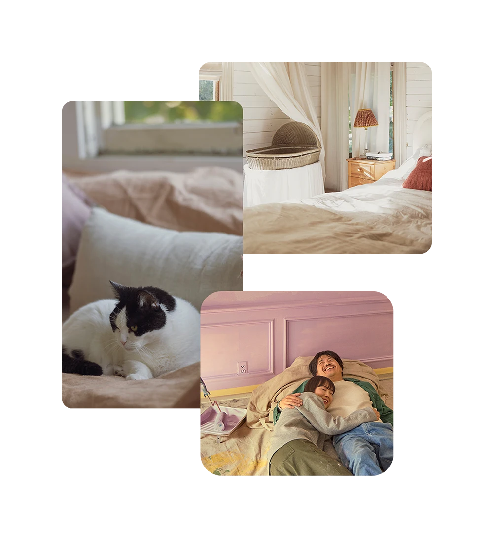 A black and white cat sitting on a couch, a room featuring a baby bassinet and a young man and woman lay on the floor in their home after painting their room pink. 