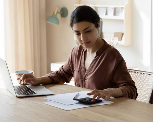 Young woman at table working on her finances.
