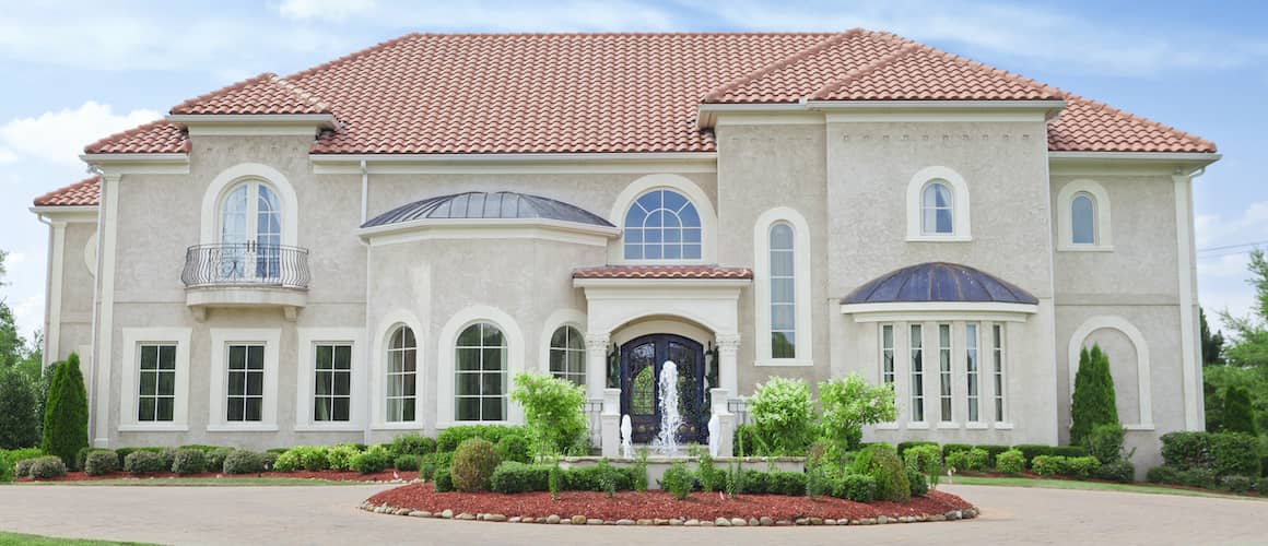 Exterior view of a stucco home with architectural details and landscaping.