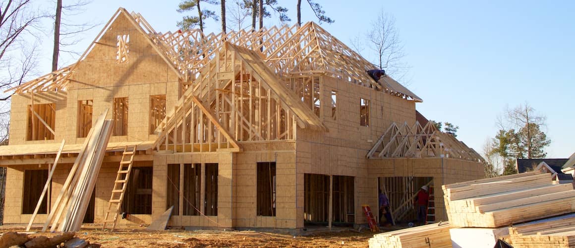 A house under construction, showcasing the building process with construction materials and equipment.