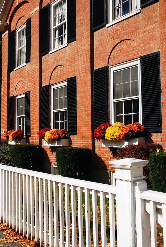 RHB Assets From IGX: Historic red brick building in Woodstock, Vermont surrounded by trees.