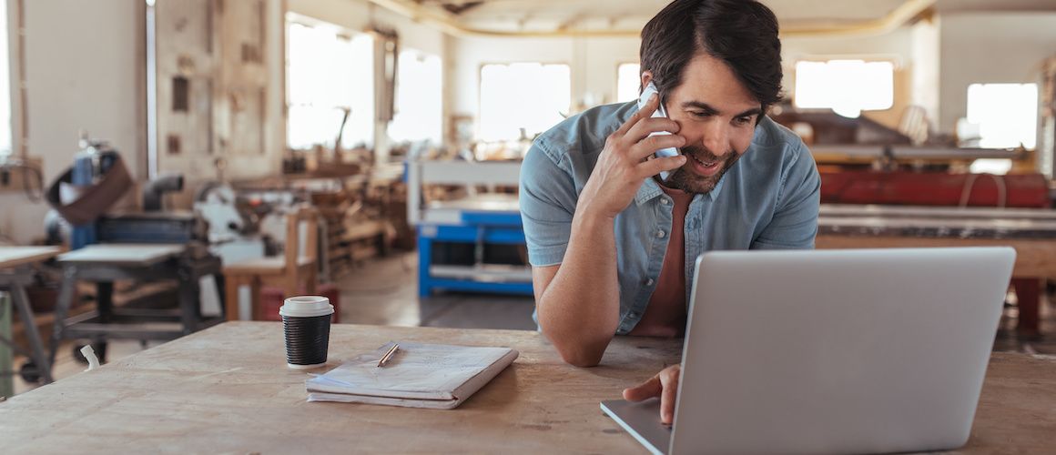 Man paying taxes on phone at coffee shop.