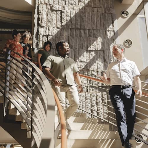 Rocket team members walking downstairs while talking together.