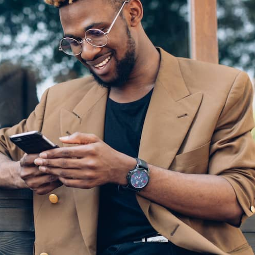 A businessman in a suit focused on his smartphone, multitasking in a modern world.