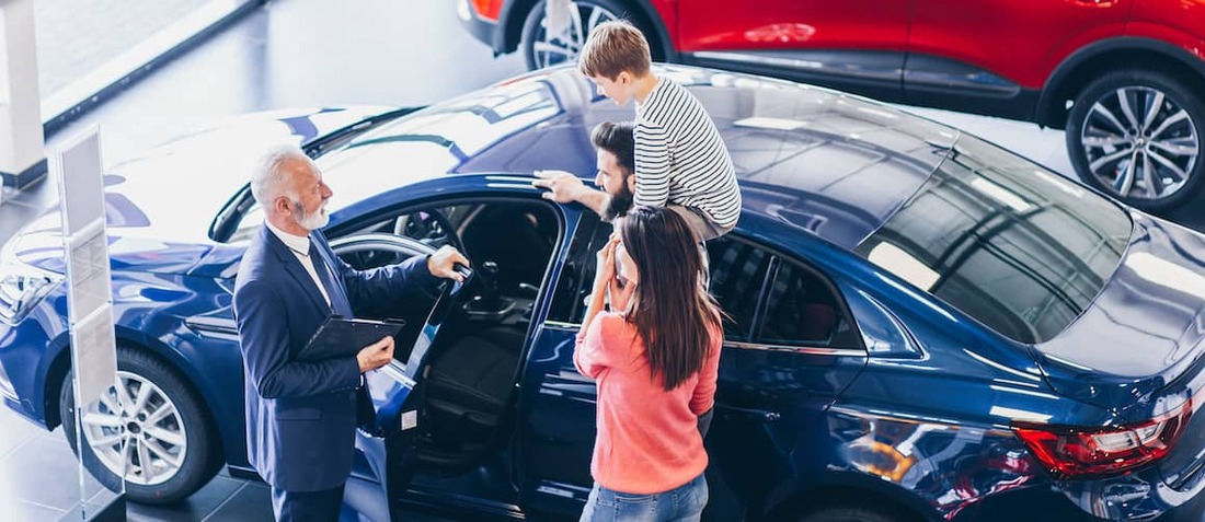 Family buying new car at showroom.