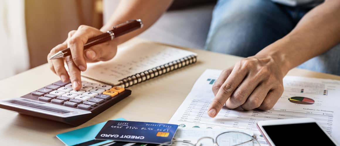 A man calculating debt, potentially involved in financial planning or debt management.