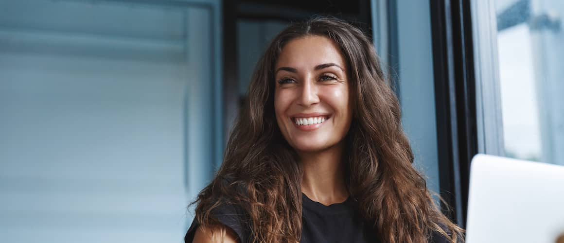 Young woman smiling while working from home.