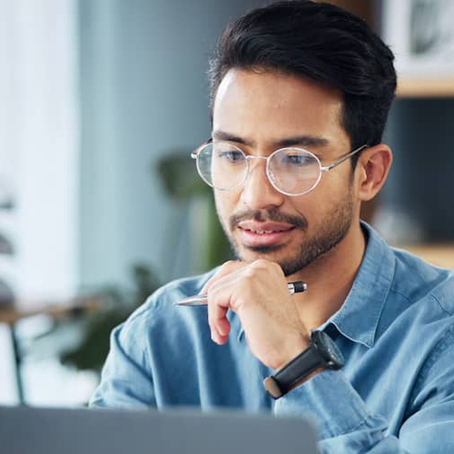 A man working on a computer, potentially doing financial research or managing real estate-related information.