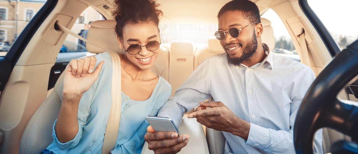 Image of couple in car, reviewing personal loan options.