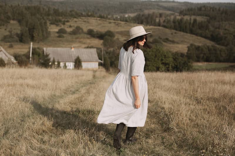 RHB Assets From IGX: A woman walking through a field with tall grass and a clear sky.