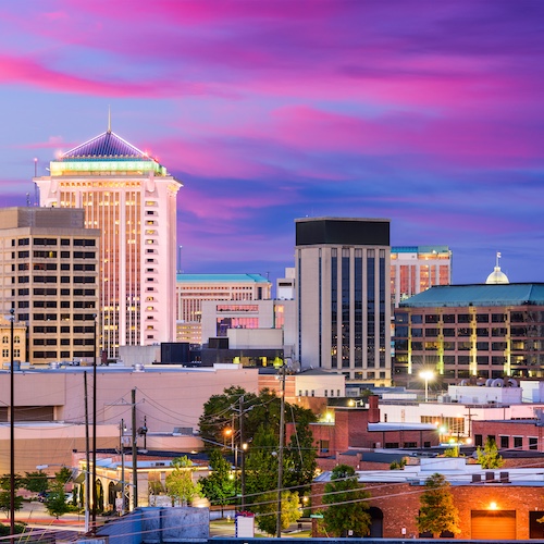 Montgomery city skyline at night with a colorful sky.