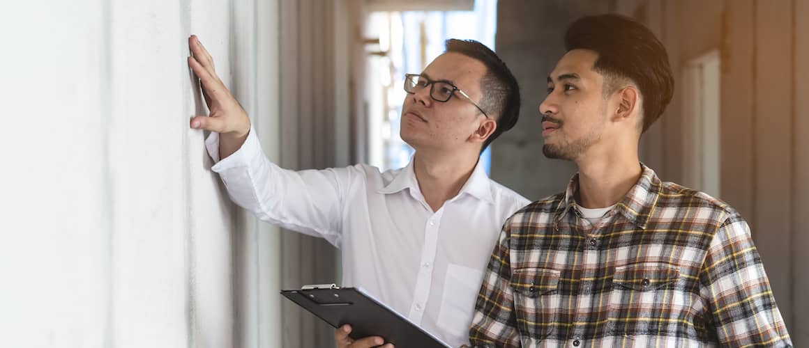 Two men inspecting a house, potentially related to home inspection or real estate assessment.