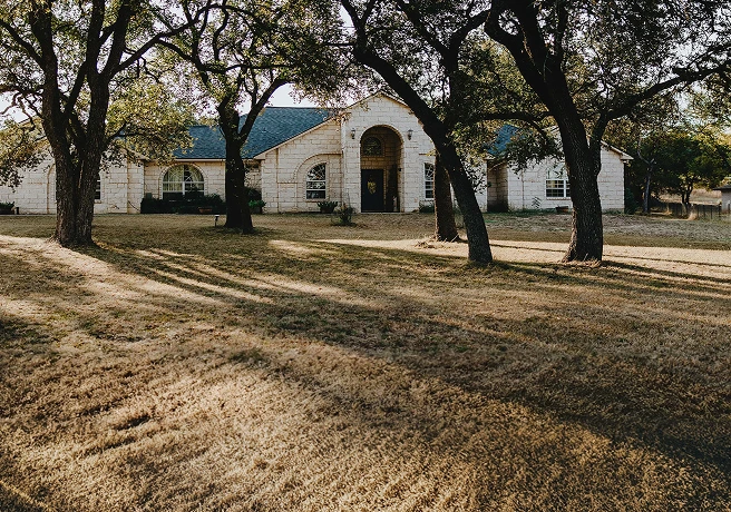 Large home with a front yard and trees