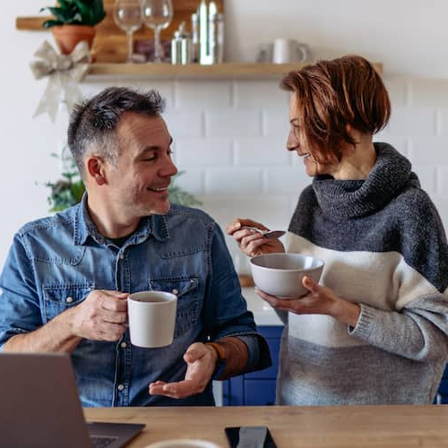 A couple having a conversation over breakfast, potentially discussing financial matters or plans.