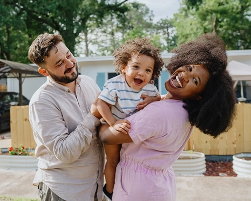 Man and woman holding laughing baby.