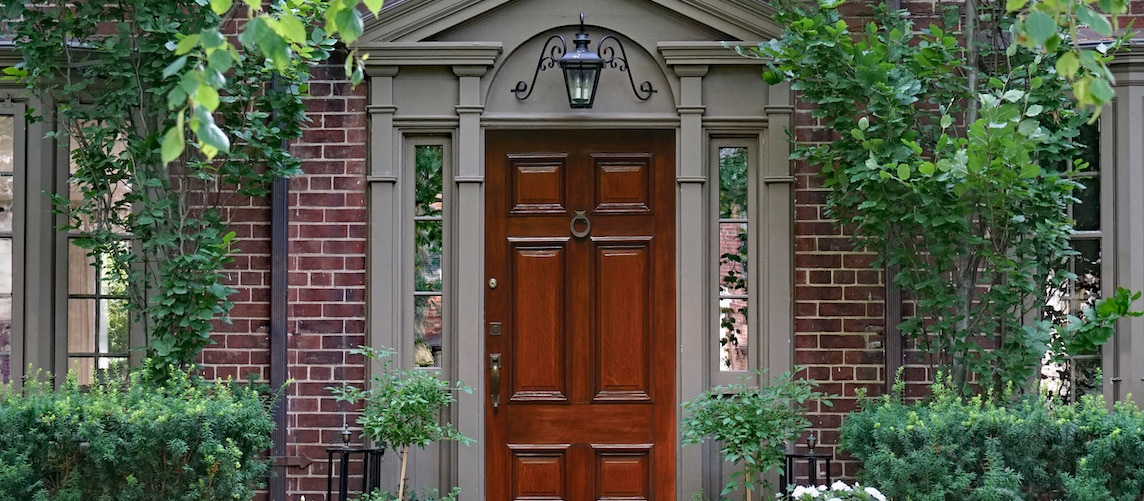 RHB Assets From IGX: Front door of a brownstone townhouse with steps and black railing