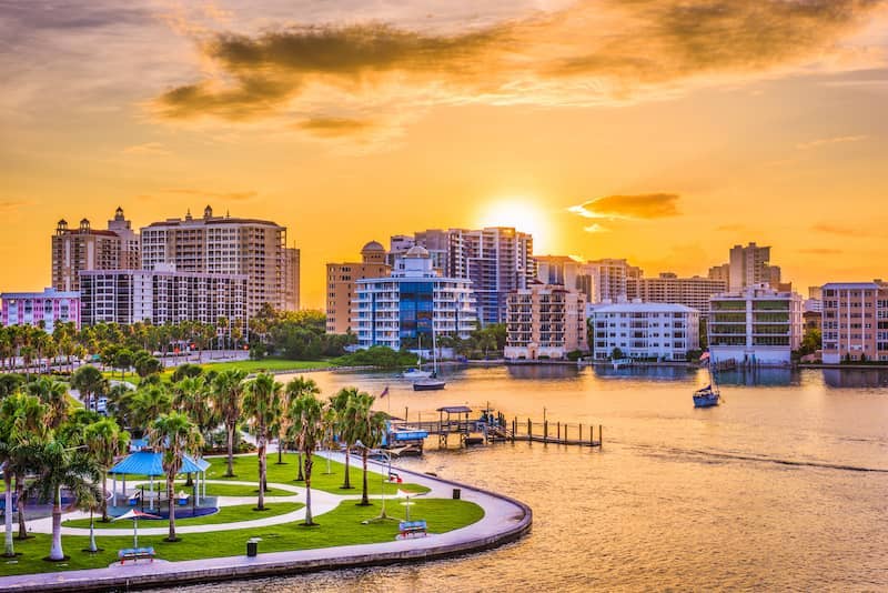 RHB Assets From IGX: Scenic view of Sarasota, Florida with palm trees and a beach.