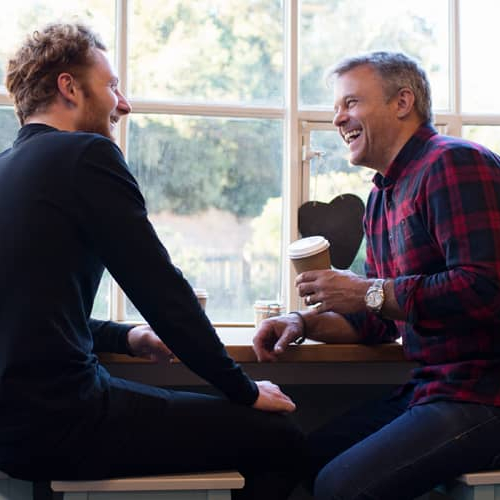Two people discussing something while drinking coffee.