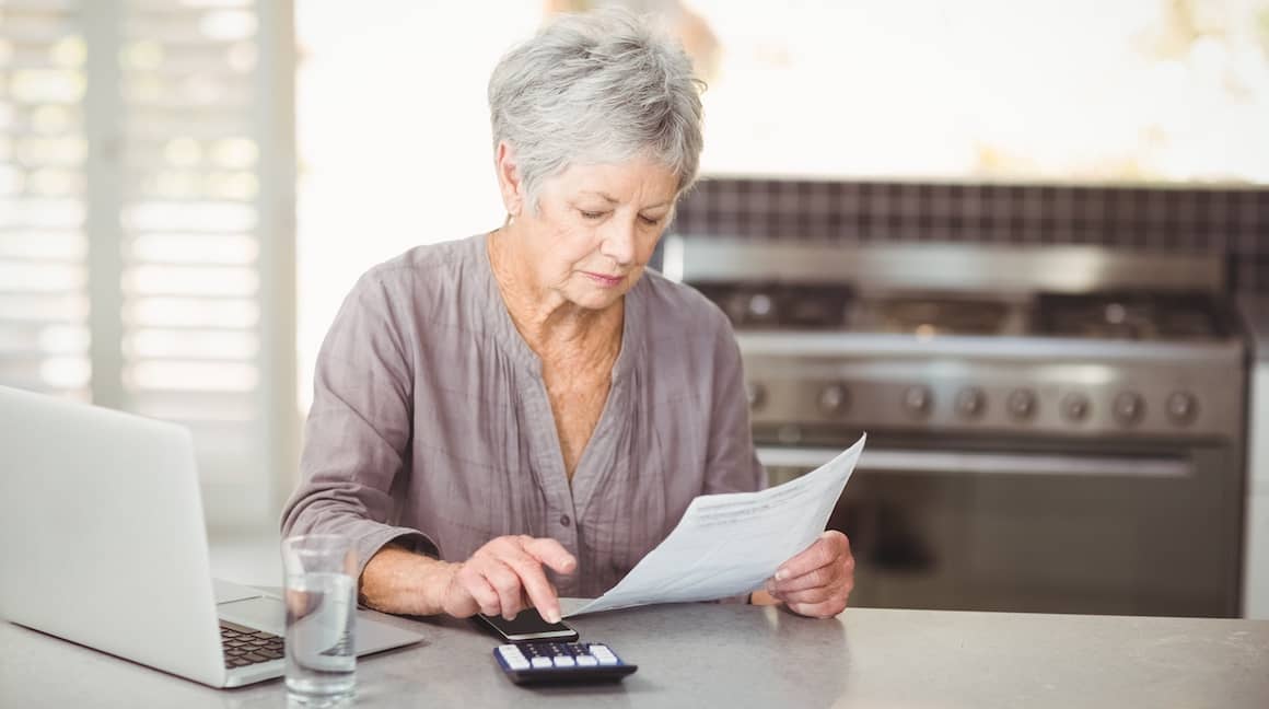 Senior woman engaged in financial tasks, possibly related to mortgage or property planning.