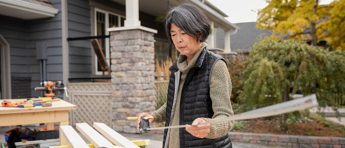 RHB Assets From IGX: Elderly Asian woman painting a wall during a home renovation