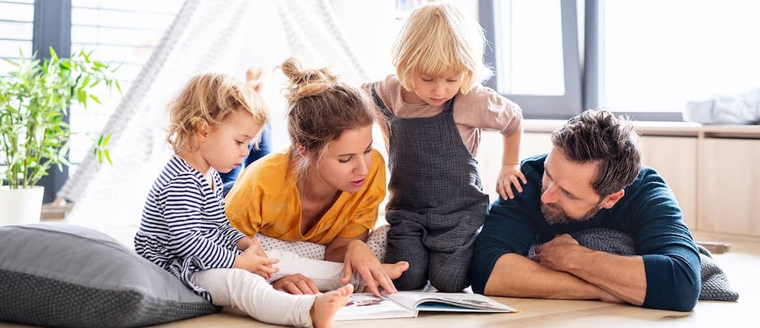 Family reading together with two kids.