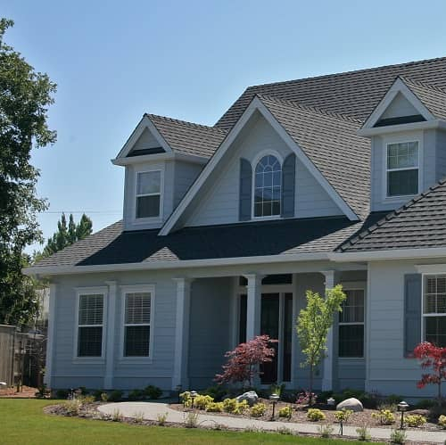 A two-story grey home in the morning light, featuring residential architecture and curb appeal.