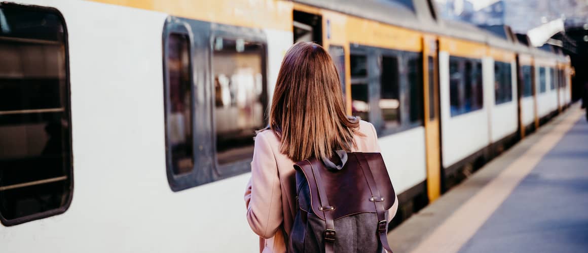 Young woman waiting on platform for light rail train.